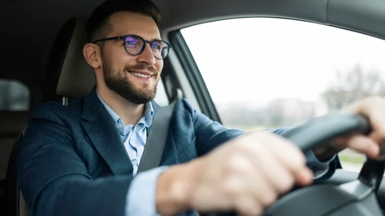 Smiling businessman driving his car