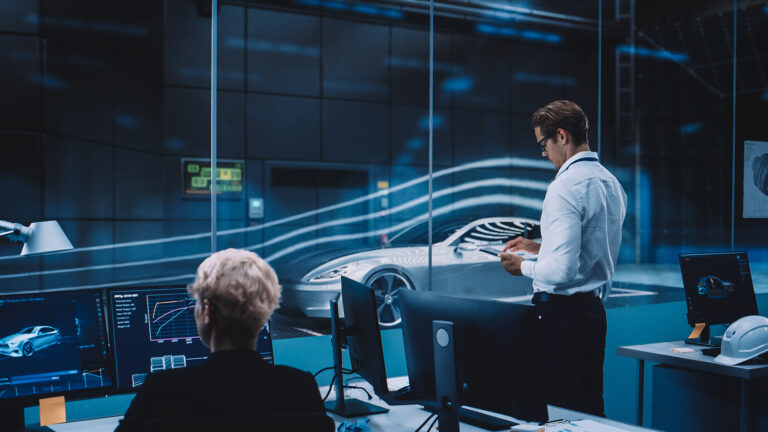 Engineering Research Agency Perform Aerodynamic Testing with a Modern Eco-Friendly Electric Sports Car in a Wind Tunnel. Chief Development Officer Works on a Tablet and Changes Testing Options